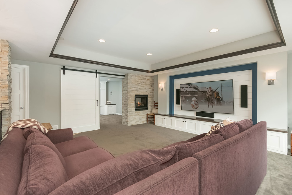 Design ideas for a large transitional look-out basement in Minneapolis with grey walls, carpet, a two-sided fireplace, a stone fireplace surround and grey floor.