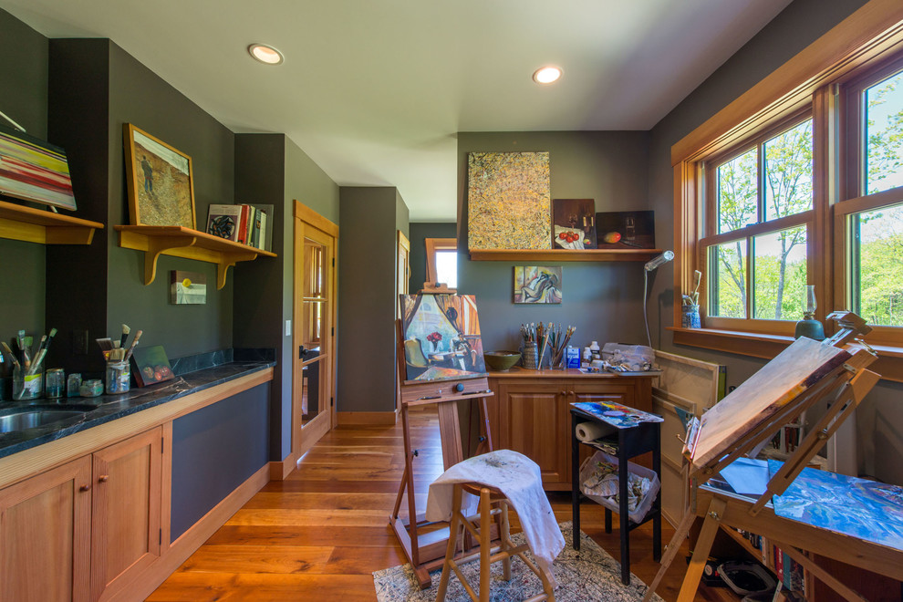Mid-sized arts and crafts home studio in Portland Maine with grey walls, medium hardwood floors and a built-in desk.