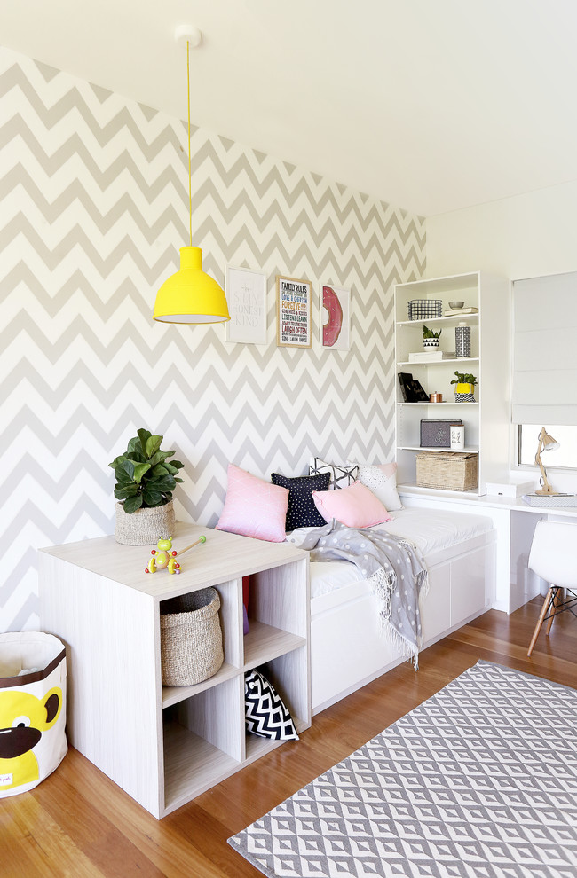 This is an example of a mid-sized contemporary study room in Brisbane with white walls, light hardwood floors and a built-in desk.