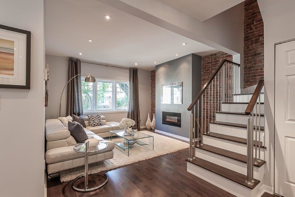 This is an example of a mid-sized modern open concept living room in Montreal with grey walls, medium hardwood floors, a ribbon fireplace and a plaster fireplace surround.