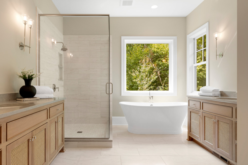 Inspiration for a classic ensuite bathroom in Minneapolis with recessed-panel cabinets, medium wood cabinets, a freestanding bath, an alcove shower, beige tiles, white tiles, beige walls, a submerged sink, engineered stone worktops, beige floors, a hinged door, grey worktops, double sinks and a built in vanity unit.