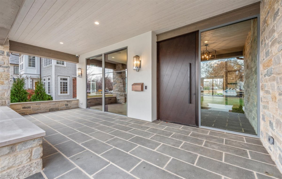 This is an example of a large transitional stone outdoor kitchen porch design in Chicago with a roof extension.