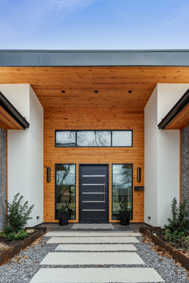 Идея дизайна: одноэтажный, серый частный загородный дом среднего размера в современном стиле с облицовкой из металла, плоской крышей и крышей из смешанных материалов