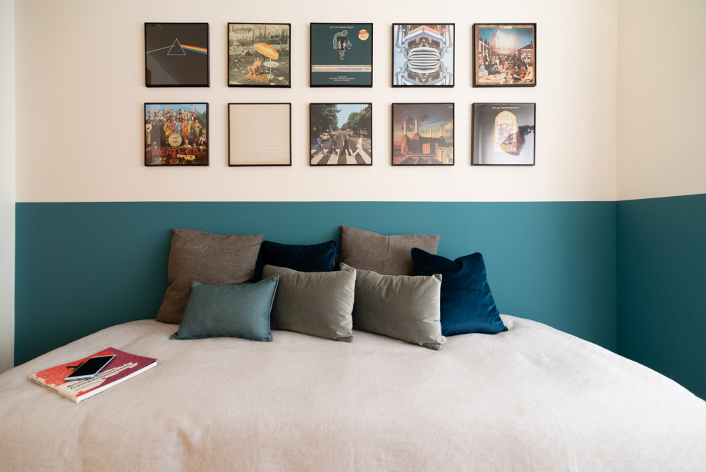 Imagen de habitación de invitados moderna pequeña con paredes azules, suelo de madera en tonos medios y papel pintado