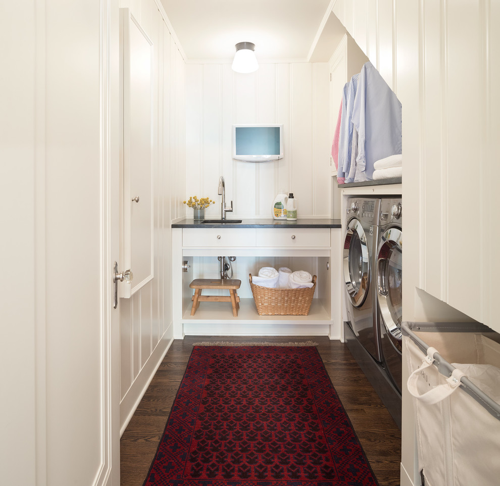 Traditional u-shaped dedicated laundry room in Minneapolis with an undermount sink, white cabinets, white walls, dark hardwood floors, a side-by-side washer and dryer, brown floor and black benchtop.