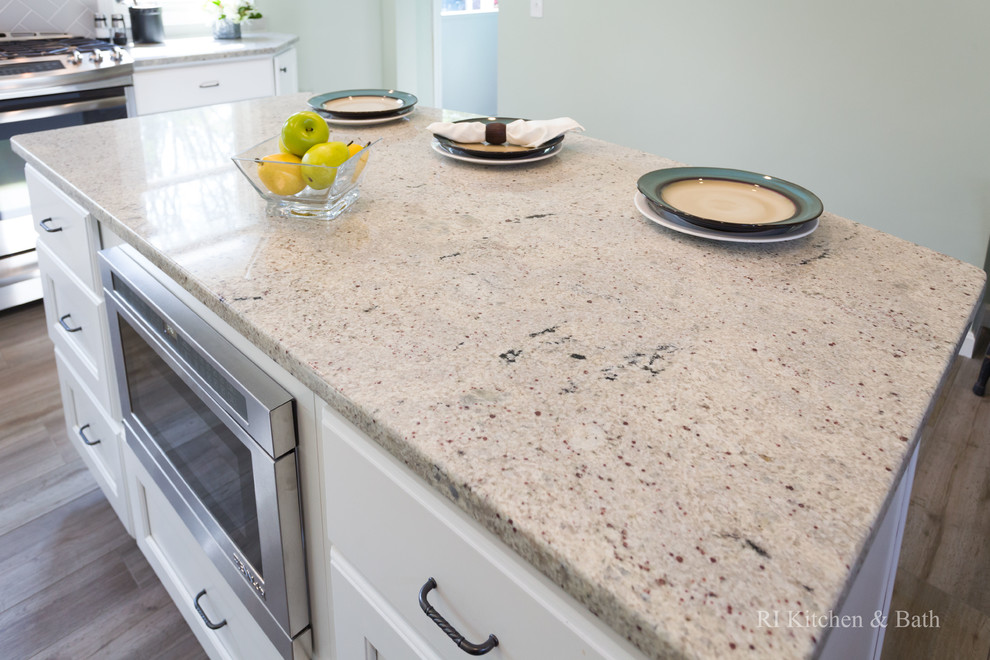 Large transitional l-shaped porcelain tile eat-in kitchen photo in Providence with an undermount sink, recessed-panel cabinets, white cabinets, granite countertops, gray backsplash, ceramic backsplash, stainless steel appliances, green walls and an island