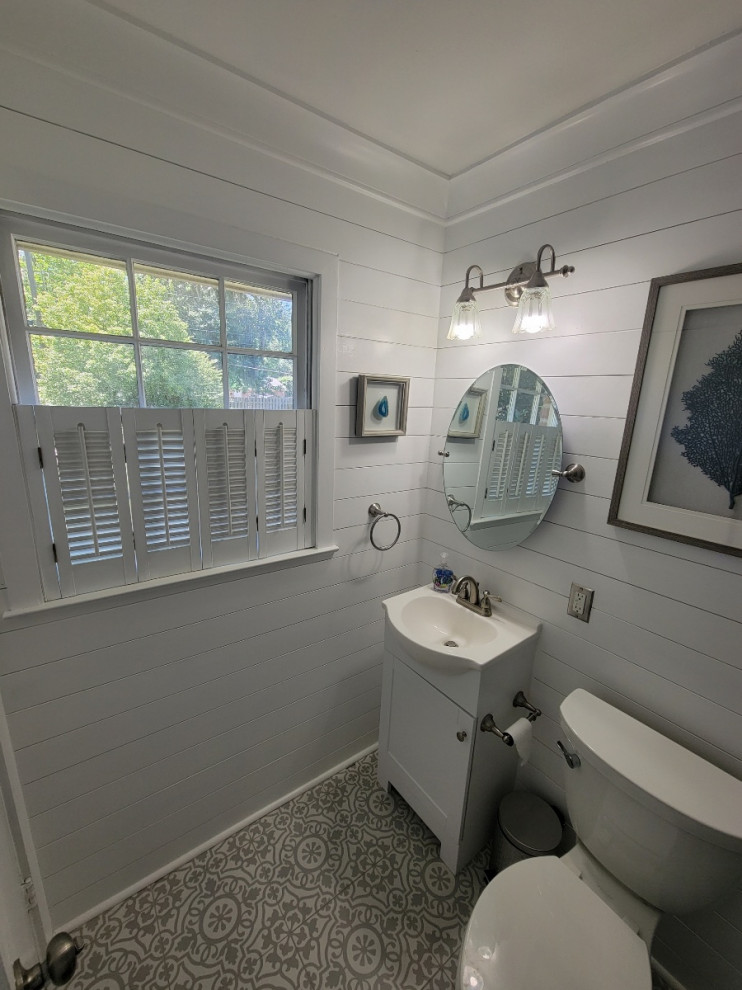 Inspiration for a small coastal master gray tile and ceramic tile ceramic tile, gray floor, single-sink, tray ceiling and shiplap wall bathroom remodel in Other with furniture-like cabinets, white cabinets, a one-piece toilet, white walls, a drop-in sink, granite countertops, a hinged shower door, white countertops and a freestanding vanity