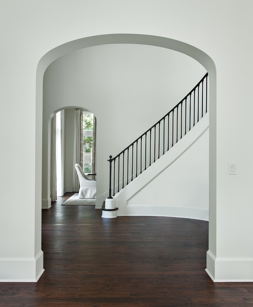 Design ideas for a traditional foyer in Houston with white walls, dark hardwood floors and brown floor.