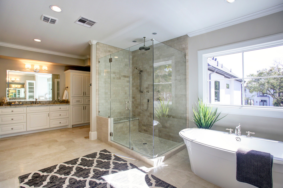 Design ideas for a large transitional master bathroom in Houston with recessed-panel cabinets, white cabinets, a freestanding tub, a double shower, gray tile, stone tile, grey walls, travertine floors, an undermount sink, granite benchtops, grey floor, a hinged shower door and grey benchtops.
