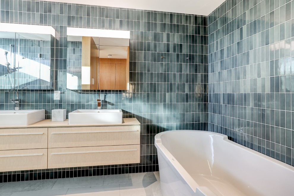 Photo of a contemporary master bathroom in New York with flat-panel cabinets, beige cabinets, a freestanding tub, an alcove shower, a wall-mount toilet, blue tile, ceramic tile, blue walls, marble floors, a console sink, engineered quartz benchtops, white floor and a hinged shower door.