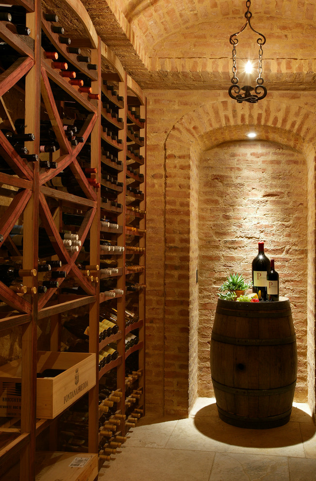 This is an example of a mid-sized mediterranean wine cellar in Orange County with storage racks, slate floors and beige floor.