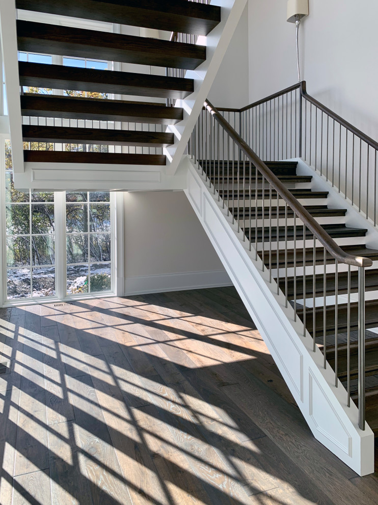 Foto de escalera suspendida contemporánea con escalones de madera y barandilla de madera