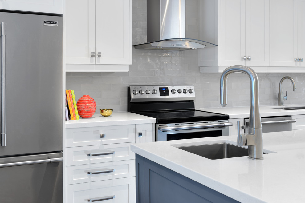 Inspiration for a mid-sized transitional single-wall dark wood floor and brown floor eat-in kitchen remodel in Toronto with a double-bowl sink, shaker cabinets, white cabinets, quartz countertops, gray backsplash, stainless steel appliances, an island and white countertops