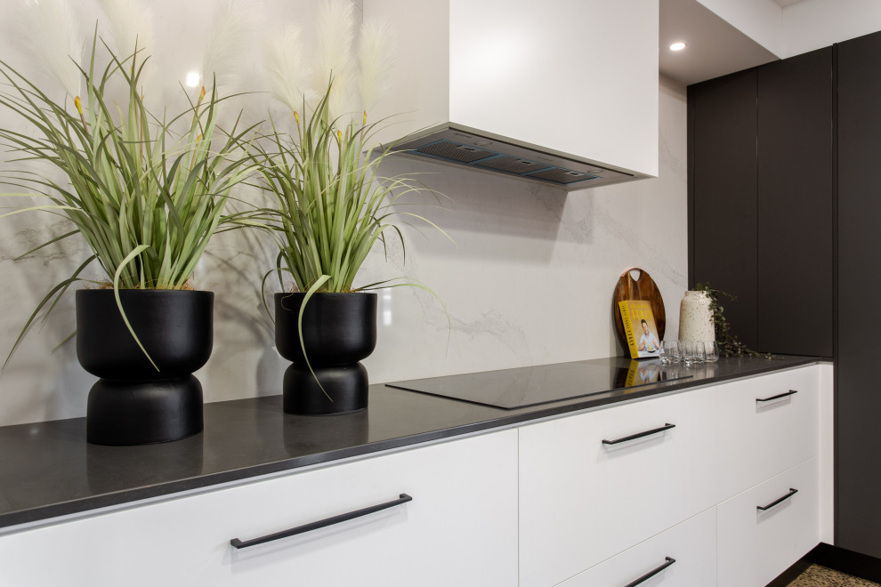 Photo of a contemporary kitchen in Adelaide with stone slab splashback and black benchtop.