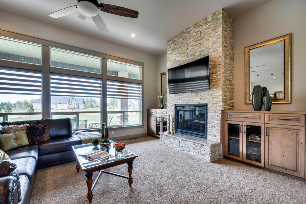 Inspiration for a large transitional open concept living room in Boise with grey walls, light hardwood floors, a standard fireplace, a stone fireplace surround and a wall-mounted tv.