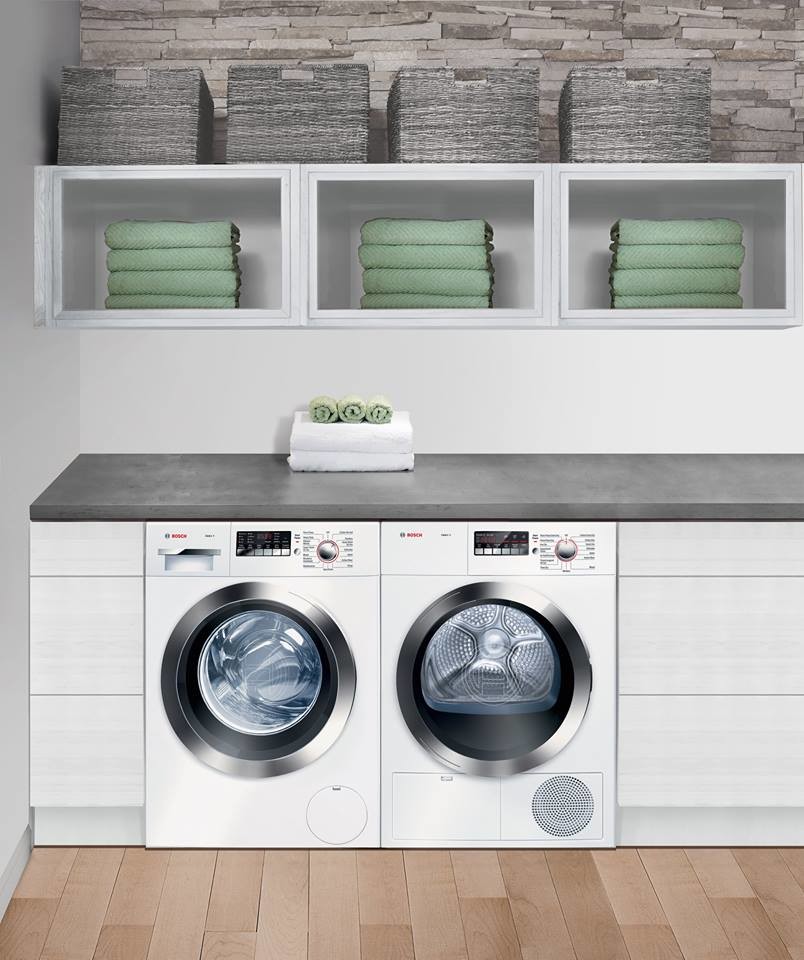Exempel på en liten modern tvättstuga, med vita skåp, vita väggar, en tvättmaskin och torktumlare bredvid varandra och ljust trägolv