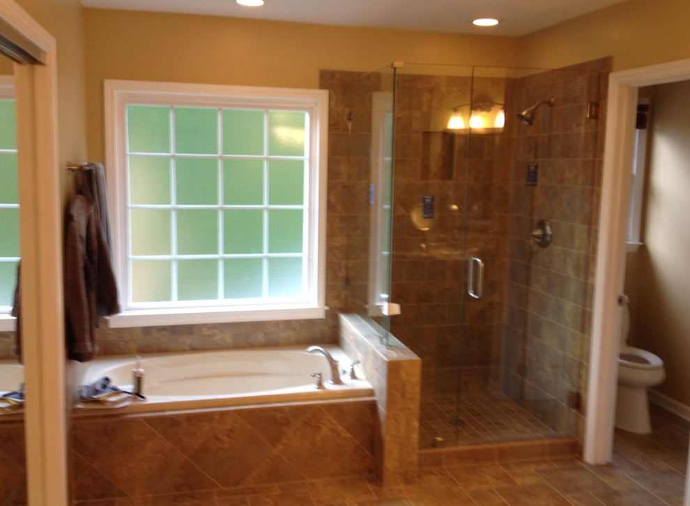 Inspiration for a mid-sized transitional master bathroom in Charlotte with an undermount sink, raised-panel cabinets, medium wood cabinets, laminate benchtops, a drop-in tub, an open shower, a two-piece toilet, brown tile, ceramic tile, yellow walls and ceramic floors.