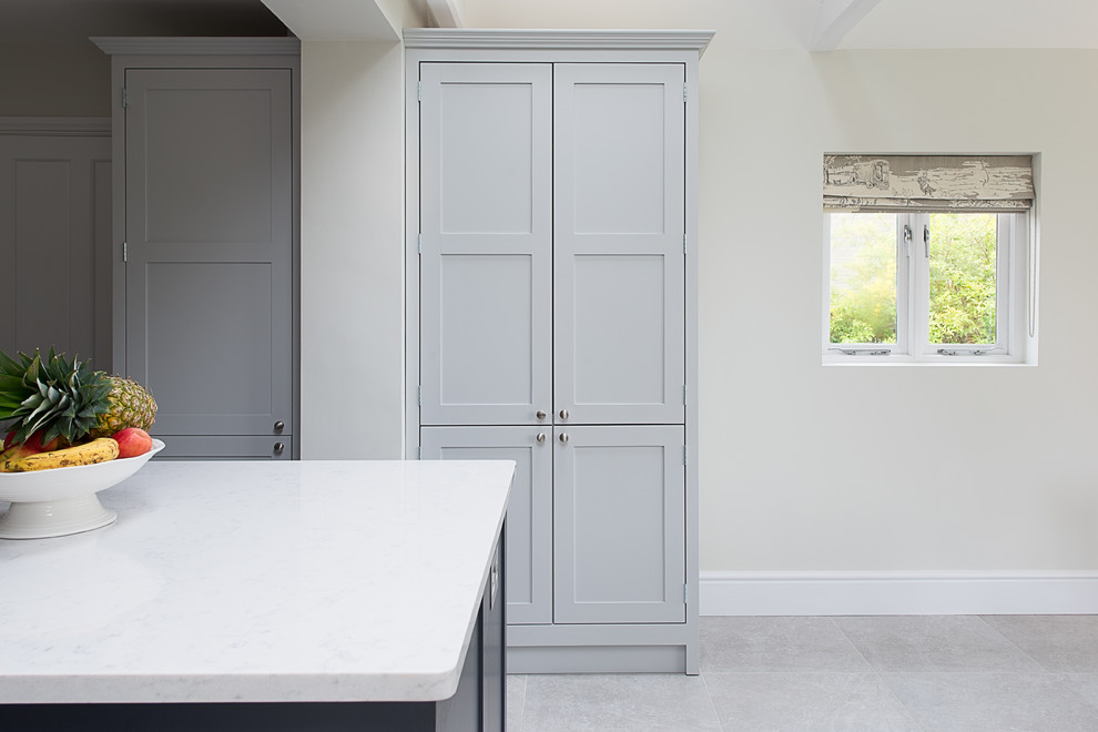 Inspiration for a mid-sized traditional eat-in kitchen in Gloucestershire with shaker cabinets, dark wood cabinets, quartz benchtops, white splashback, panelled appliances, ceramic floors and with island.