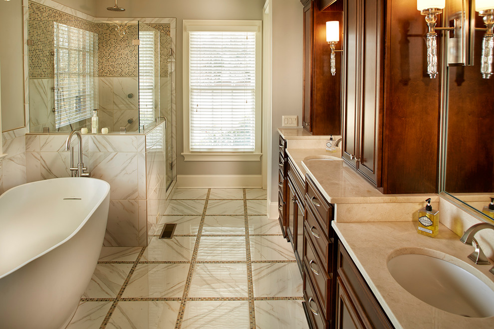 Freestanding bathtub - large transitional master beige tile, gray tile and porcelain tile porcelain tile and beige floor freestanding bathtub idea with recessed-panel cabinets, dark wood cabinets, beige walls, an undermount sink, marble countertops and a hinged shower door