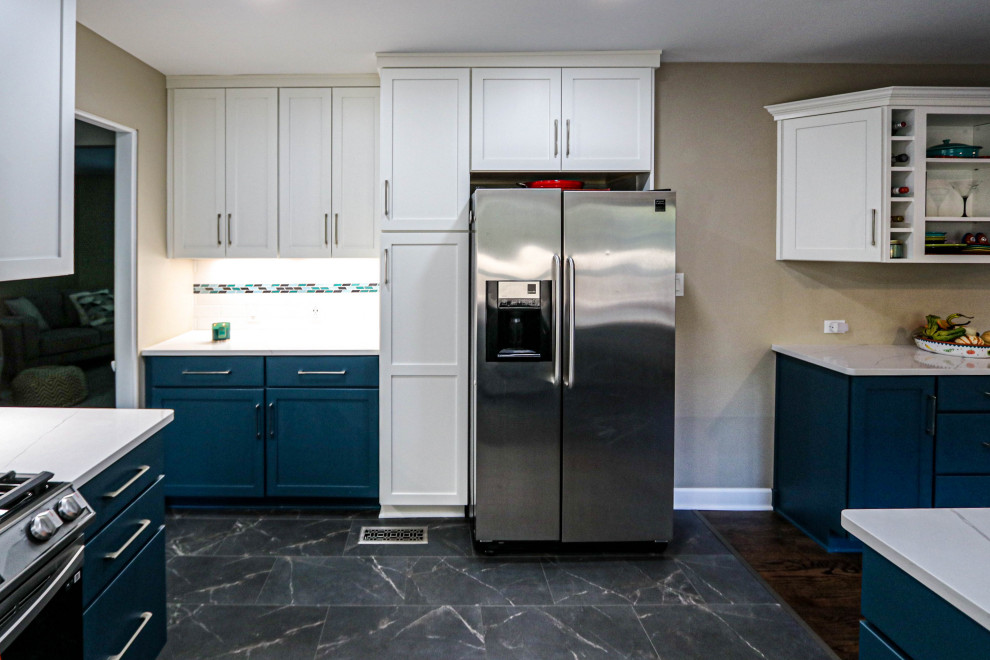 Mid-sized transitional u-shaped vinyl floor and black floor eat-in kitchen photo in Cleveland with an undermount sink, recessed-panel cabinets, green cabinets, quartz countertops, white backsplash, subway tile backsplash, stainless steel appliances, a peninsula and white countertops