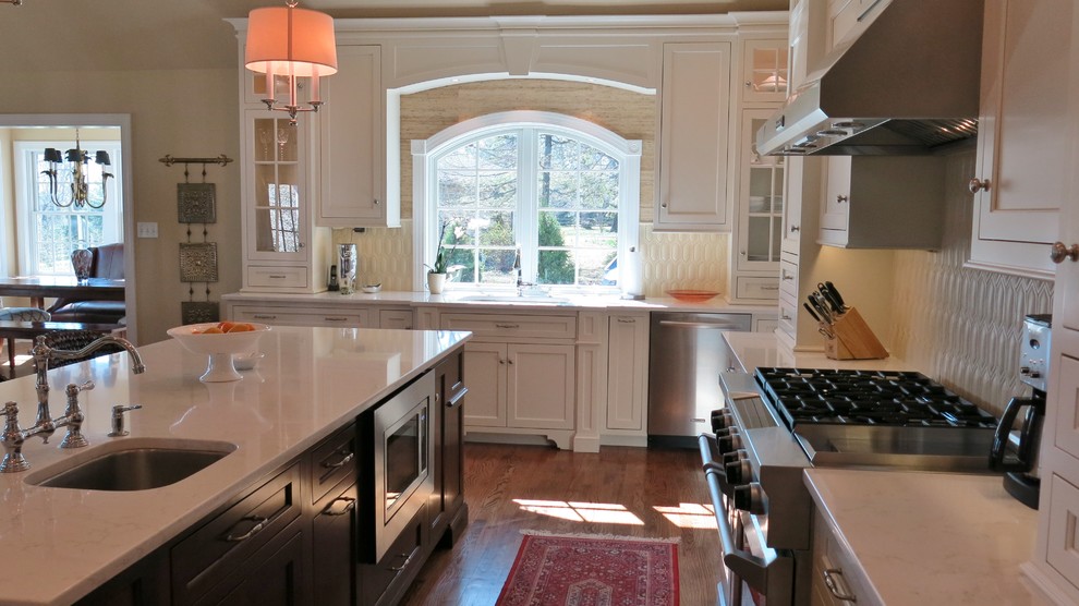 Transitional kitchen photo with white cabinets, quartz countertops and white backsplash