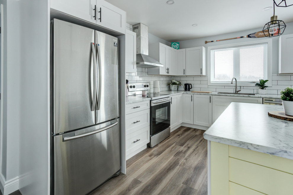 Minimalist vinyl floor and brown floor eat-in kitchen photo with shaker cabinets, white cabinets, ceramic backsplash and stainless steel appliances