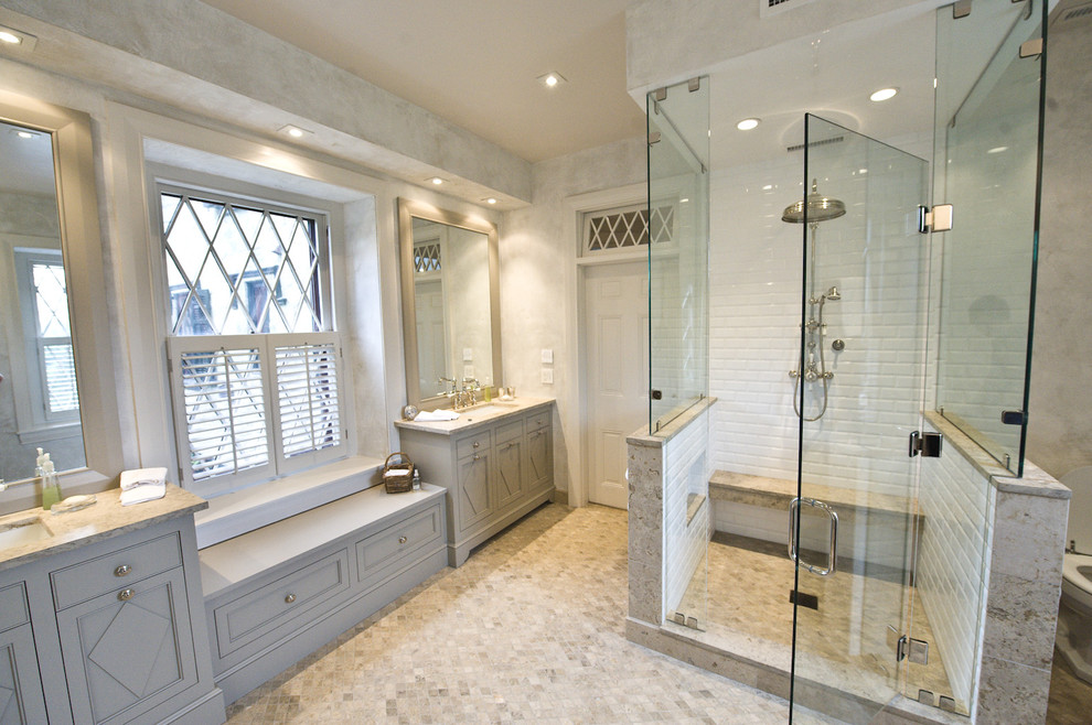 Expansive traditional master bathroom in Philadelphia with subway tile, limestone floors, limestone benchtops, multi-coloured floor and a hinged shower door.