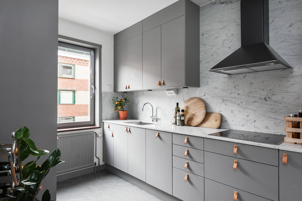 This is an example of a small scandinavian galley separate kitchen in Stockholm with flat-panel cabinets, grey cabinets, marble benchtops, marble splashback, vinyl floors, no island and grey floor.