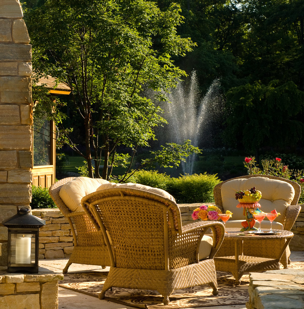 This is an example of a mid-sized traditional backyard patio in New York with a water feature, natural stone pavers and no cover.