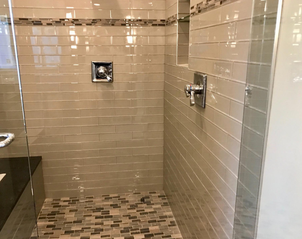 Example of a large transitional master gray tile and glass tile mosaic tile floor and multicolored floor alcove shower design with gray walls and a hinged shower door