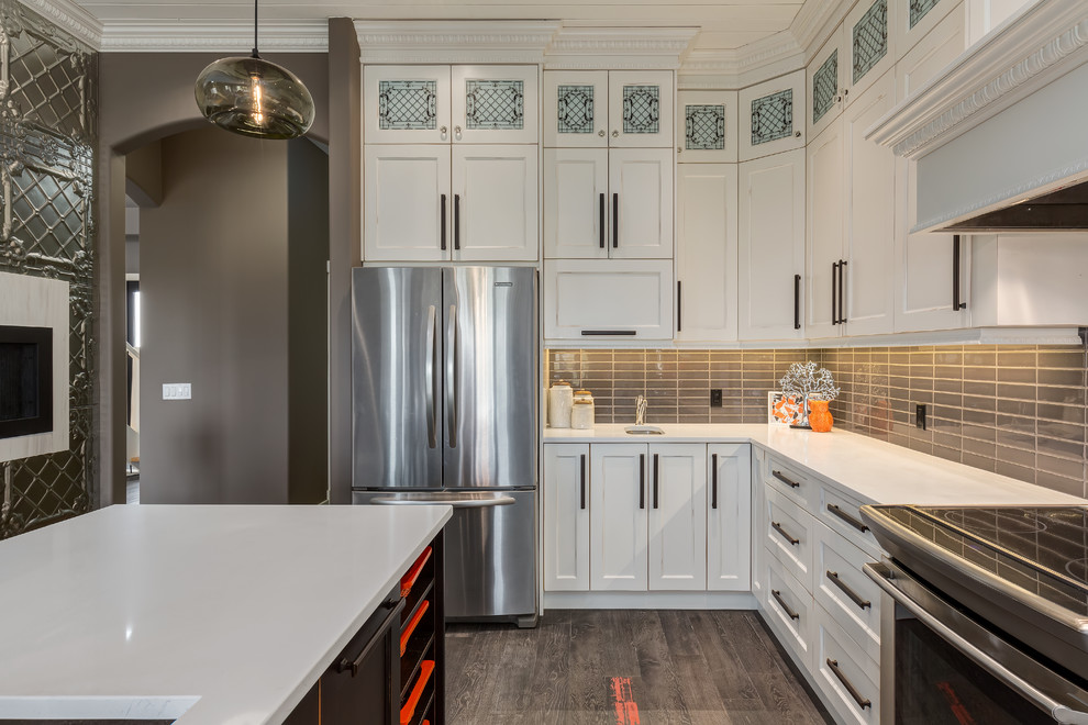 Kitchen - large contemporary l-shaped kitchen idea in Calgary with glass tile backsplash and stainless steel appliances