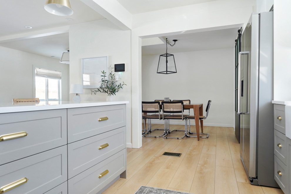 Imagen de comedor de cocina moderno de tamaño medio con paredes blancas, suelo vinílico y suelo beige