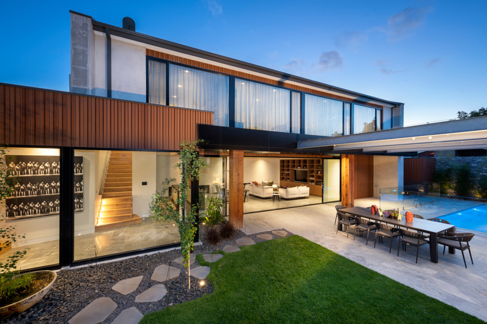 Large contemporary two-storey exterior in Melbourne with mixed siding, a flat roof and a metal roof.