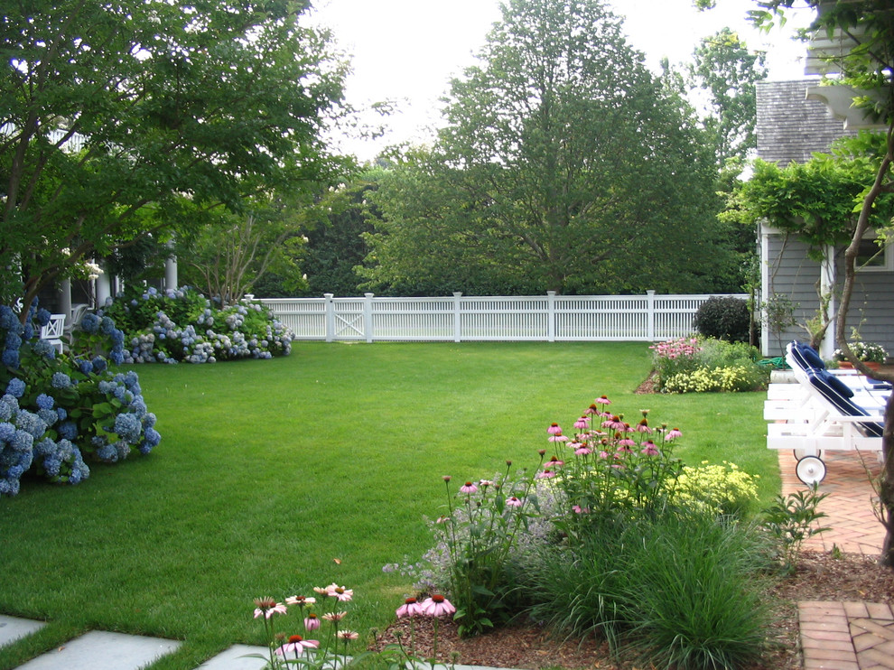 Photo of a large traditional backyard full sun formal garden in New York with a garden path and brick pavers.