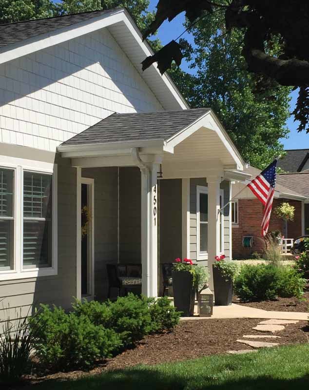 Photo of a mid-sized traditional one-storey grey house exterior in Chicago with mixed siding, a gable roof, a shingle roof, a grey roof and clapboard siding.