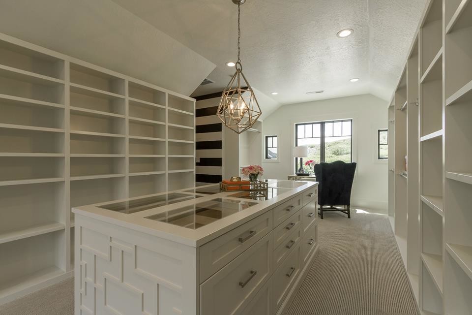 This is an example of a large transitional gender-neutral walk-in wardrobe in Salt Lake City with shaker cabinets, white cabinets, light hardwood floors and beige floor.