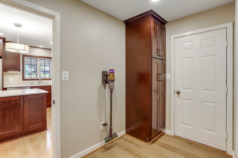 Design ideas for a small transitional mudroom in DC Metro with a medium wood front door.