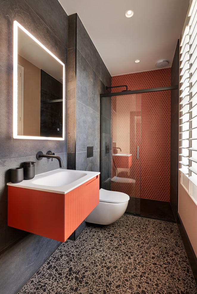 Источник вдохновения для домашнего уюта: ванная комната в современном стиле с плоскими фасадами, оранжевыми фасадами, открытым душем, инсталляцией, серой плиткой, плиткой мозаикой, серыми стенами, полом из керамогранита, монолитной раковиной, черным полом, открытым душем, белой столешницей, акцентной стеной, тумбой под одну раковину и подвесной тумбой