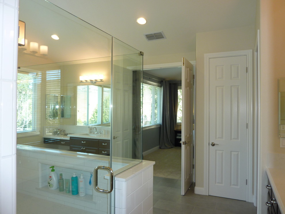 This is an example of a mid-sized contemporary master bathroom in San Francisco with flat-panel cabinets, black cabinets, white tile, porcelain tile, white walls, porcelain floors, an undermount sink and marble benchtops.