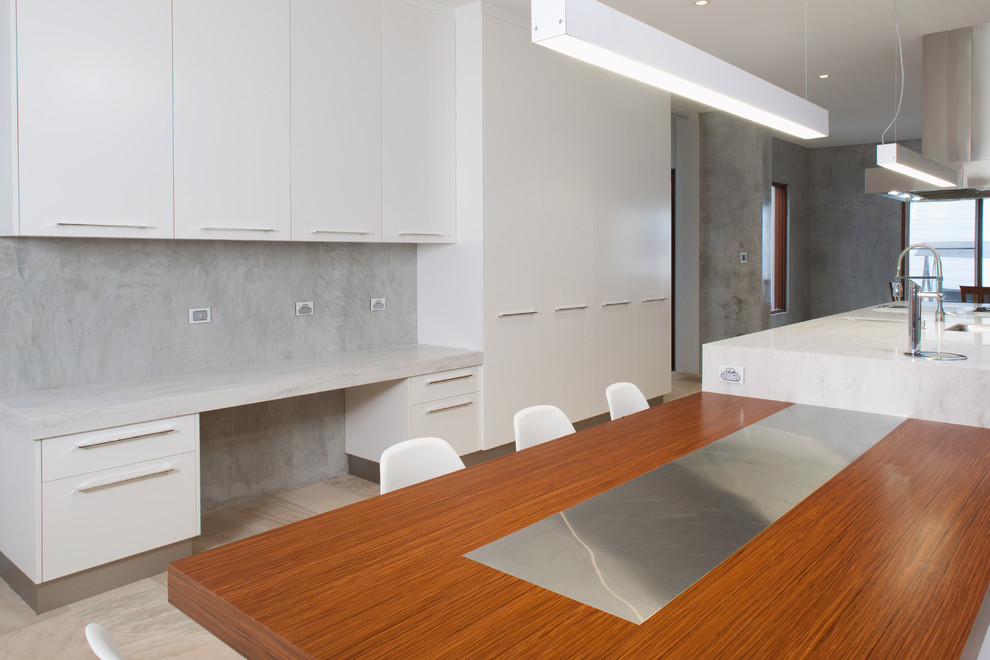 Large modern kitchen in Perth with flat-panel cabinets, white cabinets, solid surface benchtops, grey splashback, stainless steel appliances, multiple islands and grey benchtop.