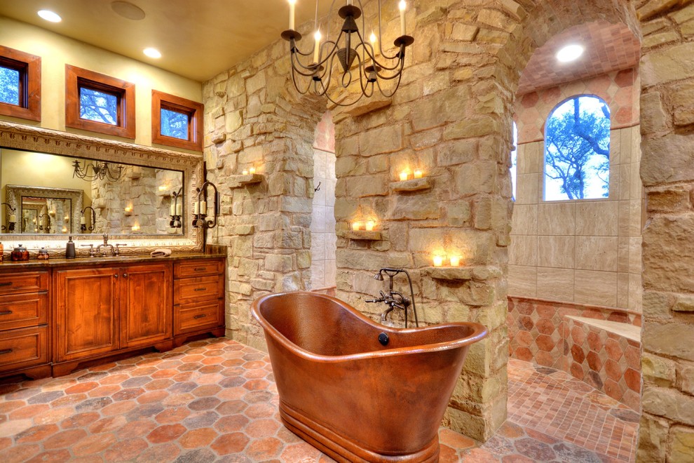 Example of a mountain style master freestanding bathtub design in Austin with an undermount sink, flat-panel cabinets, medium tone wood cabinets and granite countertops
