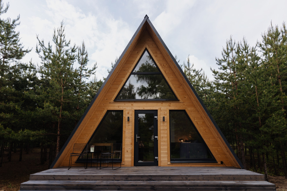 Пример оригинального дизайна: двухэтажный, деревянный мини дом в скандинавском стиле с двускатной крышей, металлической крышей, серой крышей и отделкой планкеном