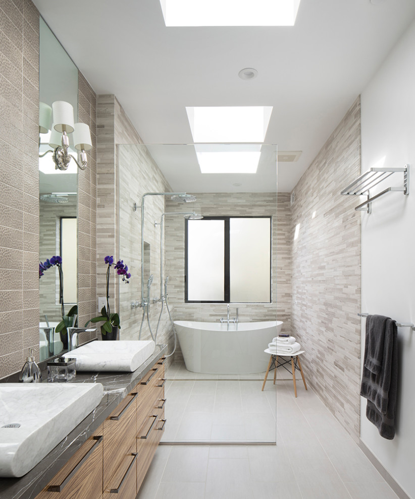 Design ideas for a contemporary bathroom in San Francisco with flat-panel cabinets, medium wood cabinets, a freestanding tub, a double shower, beige tile, ceramic tile, beige walls, ceramic floors, a vessel sink, marble benchtops, beige floor, an open shower, grey benchtops, a niche, a double vanity and a floating vanity.