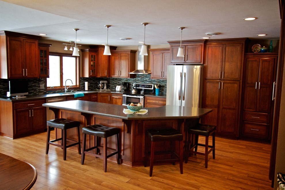 Open concept kitchen - mid-sized l-shaped light wood floor open concept kitchen idea with an undermount sink, shaker cabinets, dark wood cabinets, laminate countertops, multicolored backsplash, glass tile backsplash, stainless steel appliances and an island