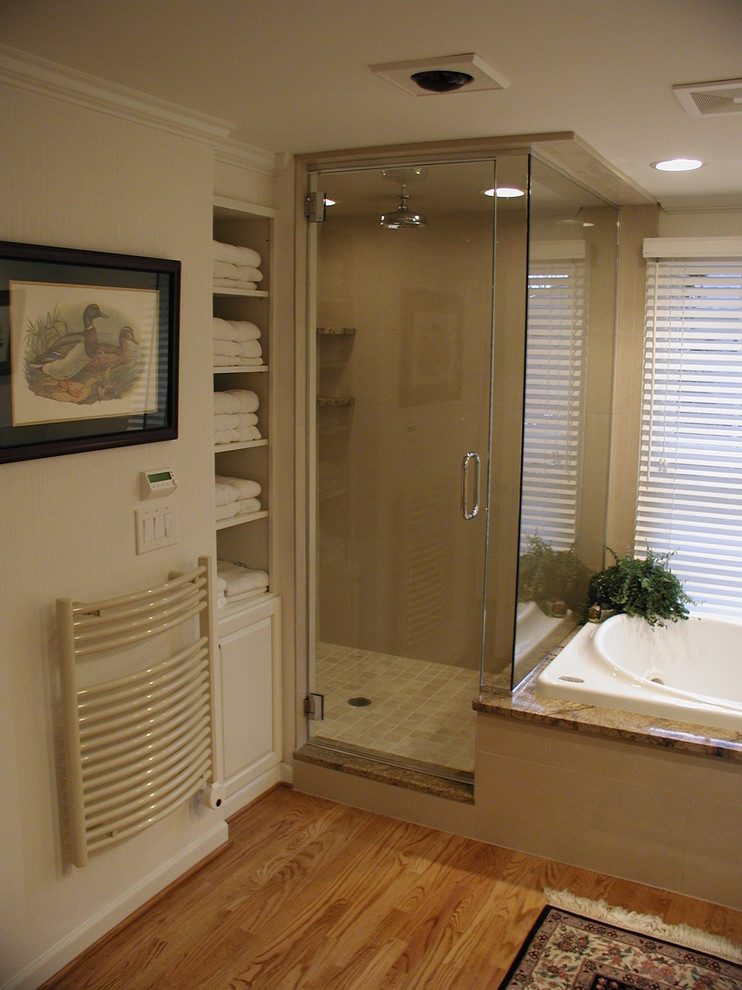 This is an example of a traditional bathroom in Detroit with raised-panel cabinets, white cabinets, granite benchtops, a drop-in tub, a corner shower, beige tile and stone tile.