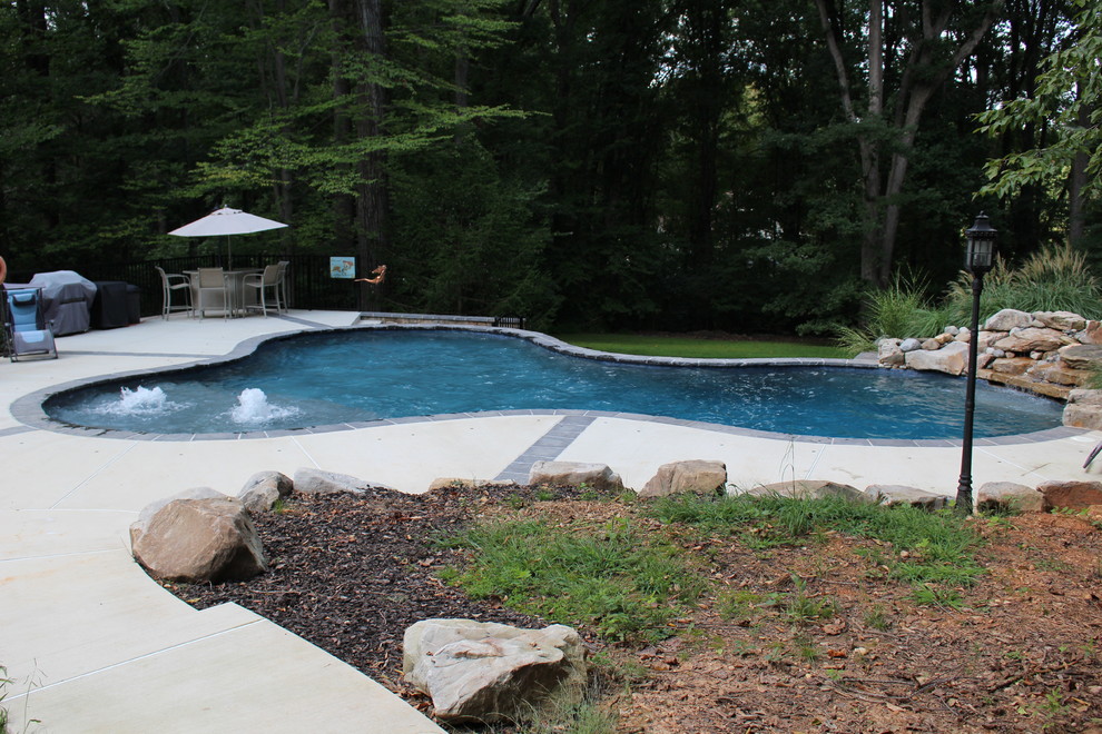 Inspiration for a large rustic backyard custom-shaped natural pool fountain remodel in DC Metro with decking