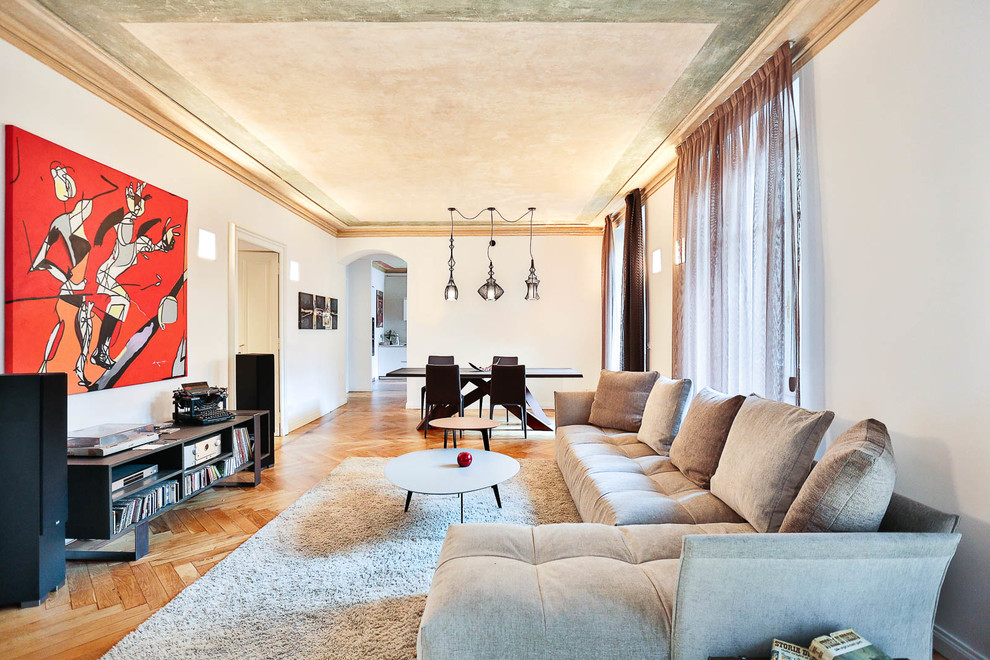 This is an example of a large contemporary formal open concept living room in Turin with white walls, medium hardwood floors and no tv.