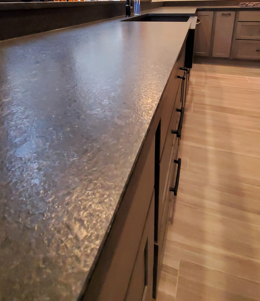 Kitchen - mid-sized transitional porcelain tile and gray floor kitchen idea with a farmhouse sink, shaker cabinets, gray cabinets, granite countertops, black backsplash, stone slab backsplash, stainless steel appliances, an island and black countertops