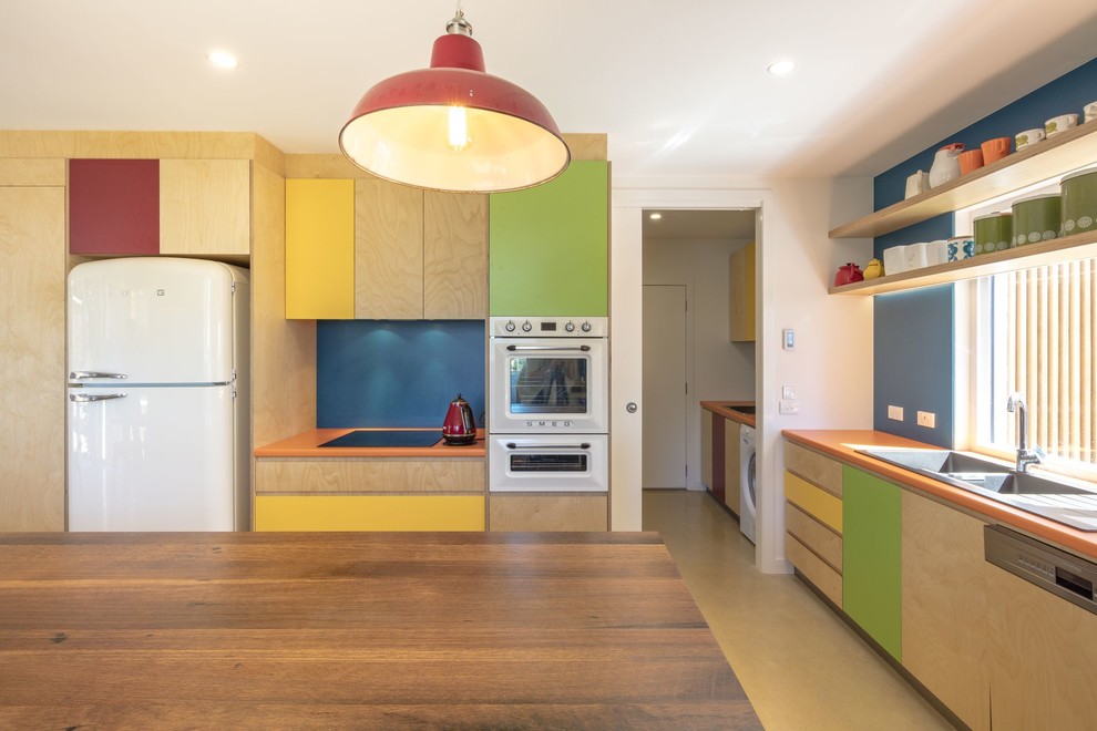 This is an example of a mid-sized contemporary galley eat-in kitchen in Canberra - Queanbeyan with a double-bowl sink, flat-panel cabinets, light wood cabinets, blue splashback, coloured appliances, with island and orange benchtop.
