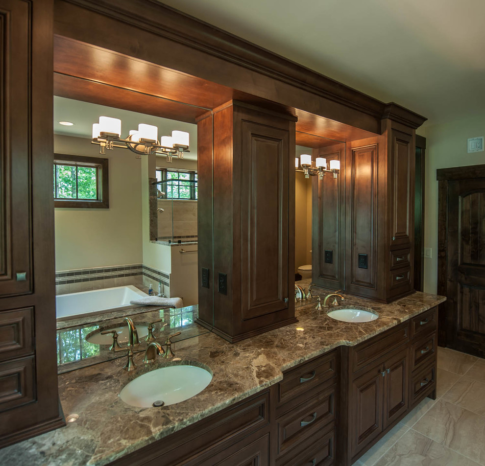 This is an example of a mid-sized transitional master bathroom in Other with raised-panel cabinets, dark wood cabinets, a drop-in tub, an alcove shower, a two-piece toilet, beige tile, ceramic tile, beige walls, ceramic floors, an undermount sink and granite benchtops.
